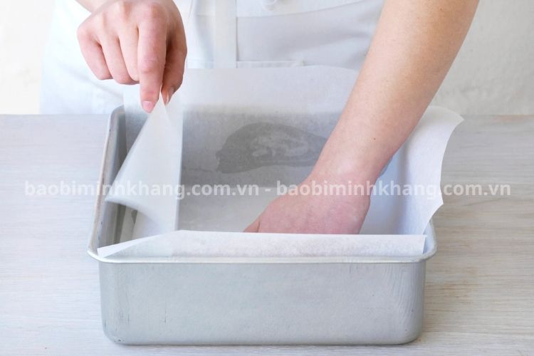 Bạn cắt và xếp giấy nến vừa vặn với kích thước khuôn bánh.