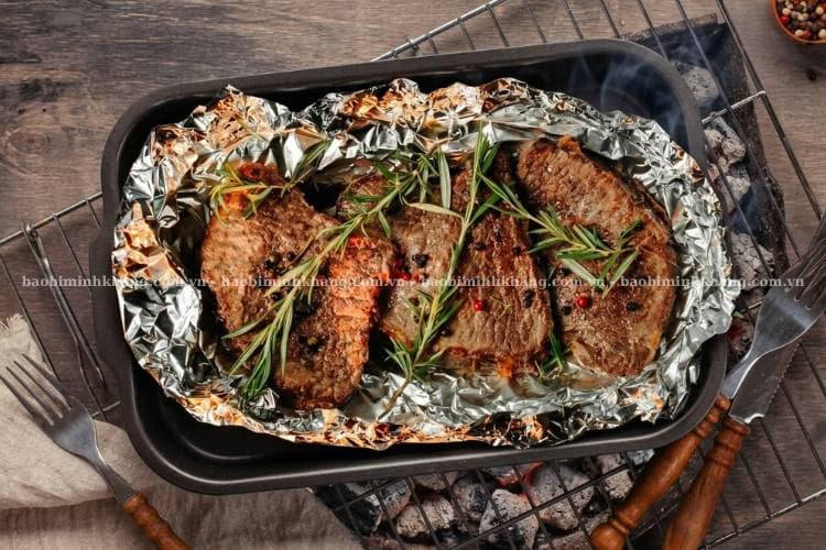 Bò nướng giấy bạc bằng bếp than bạn nên dùng hai lớp giấy bạc để hạn chế mỡ chảy làm lửa bùng lên